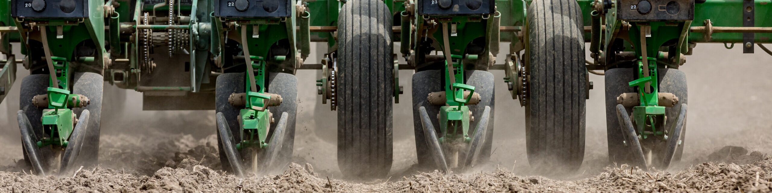 Closeup of tractor and planter in farm field planting corn or so